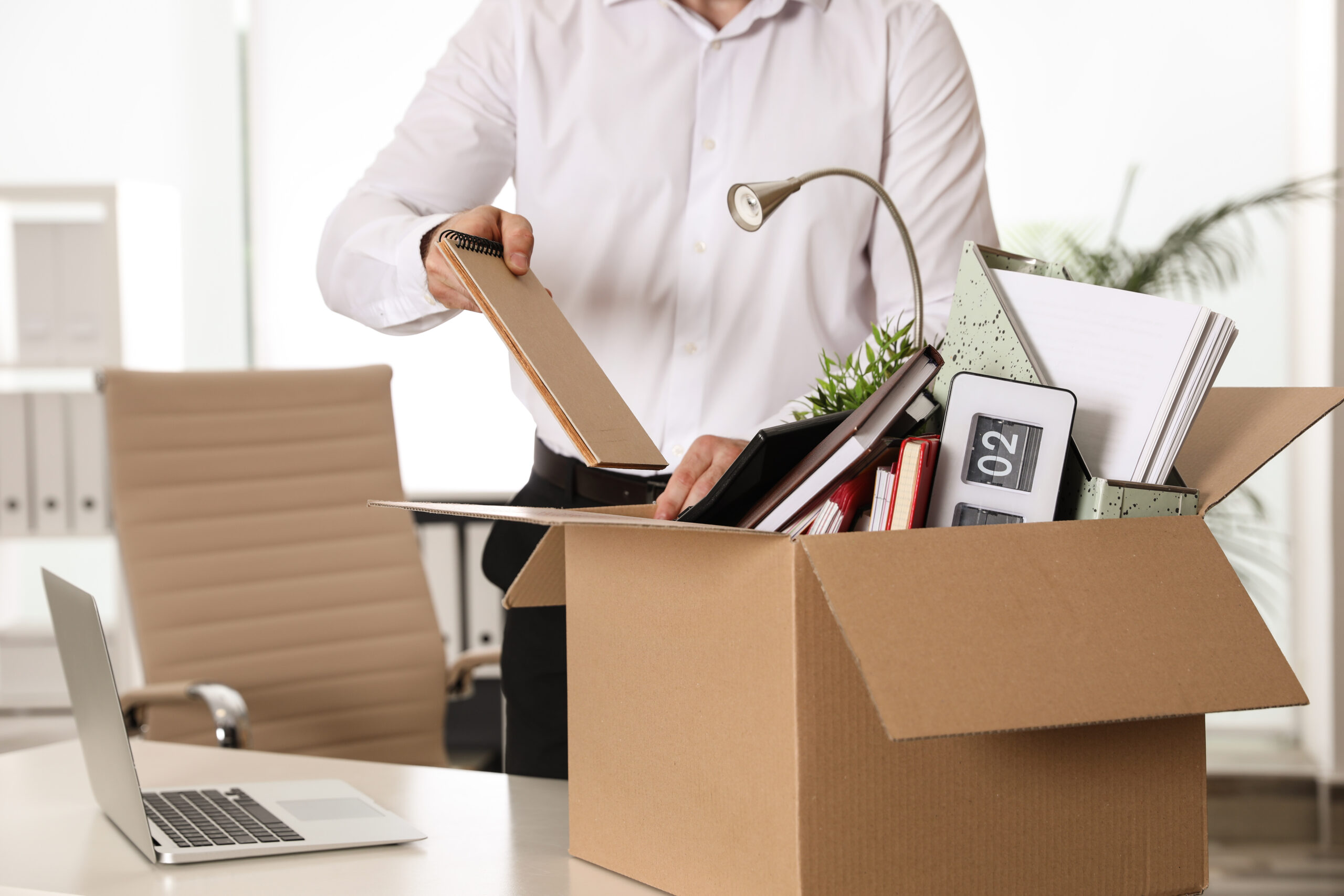 Young man packing stuff in box 