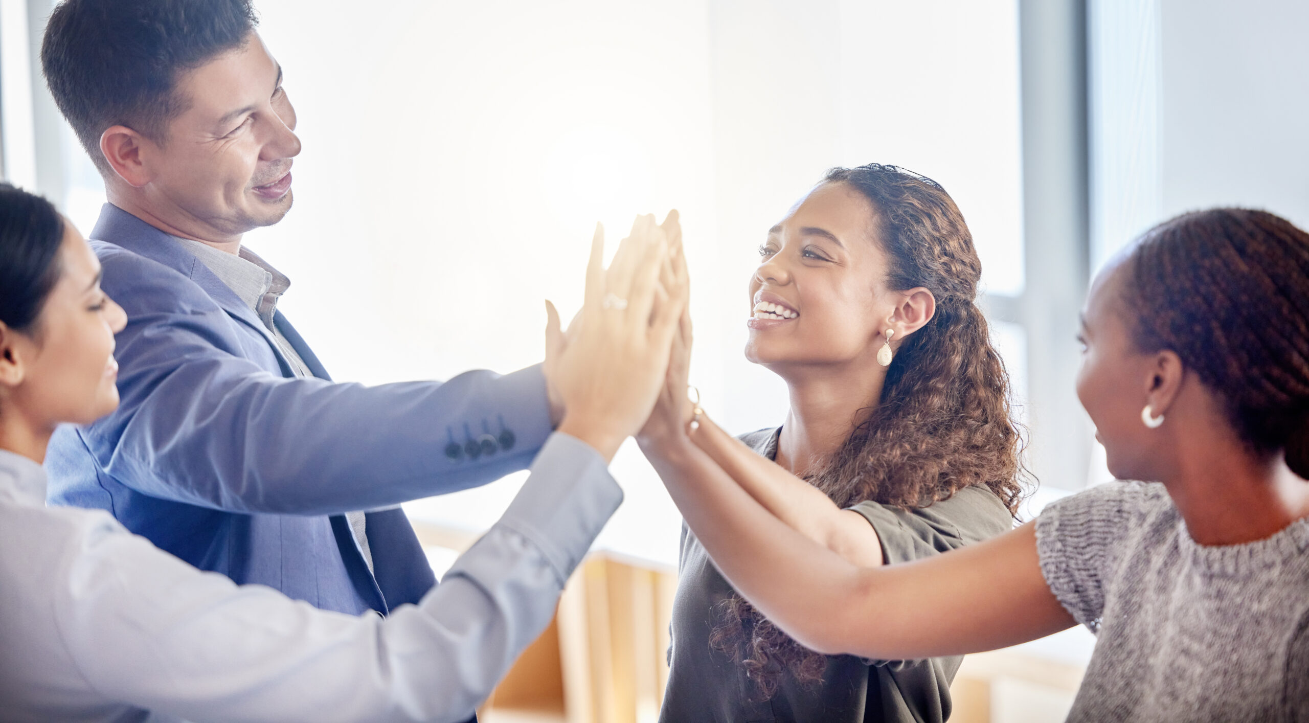 Business people, meeting and high five in team building, agreement or collaboration in unity at the office. Happy group of employees touching hands in teamwork, motivation or celebration for goals.