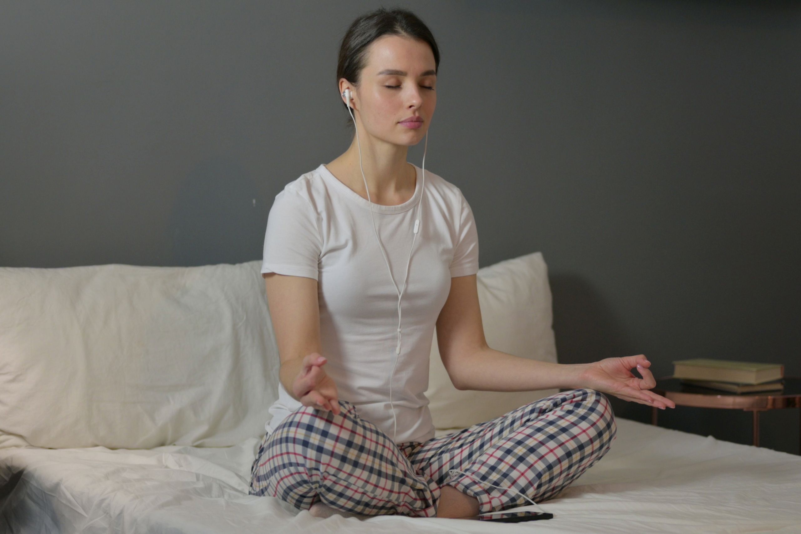 young woman meditating in bed 